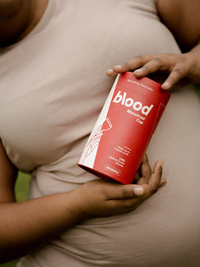 a girl holds blood menstrual cup's packaging in her hands